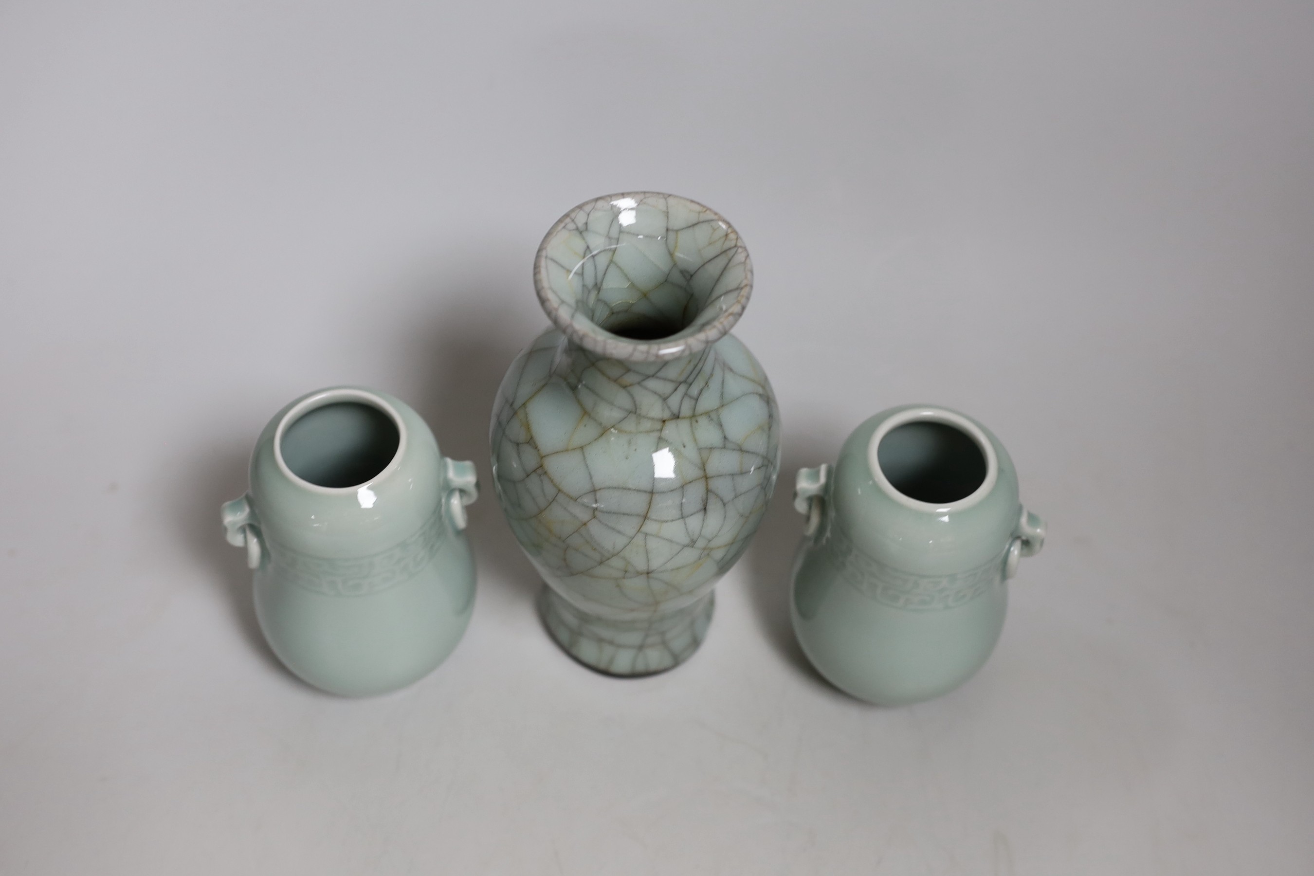 A Chinese celadon crackle ware vase and a pair of smaller celadon vases, largest 16.cms